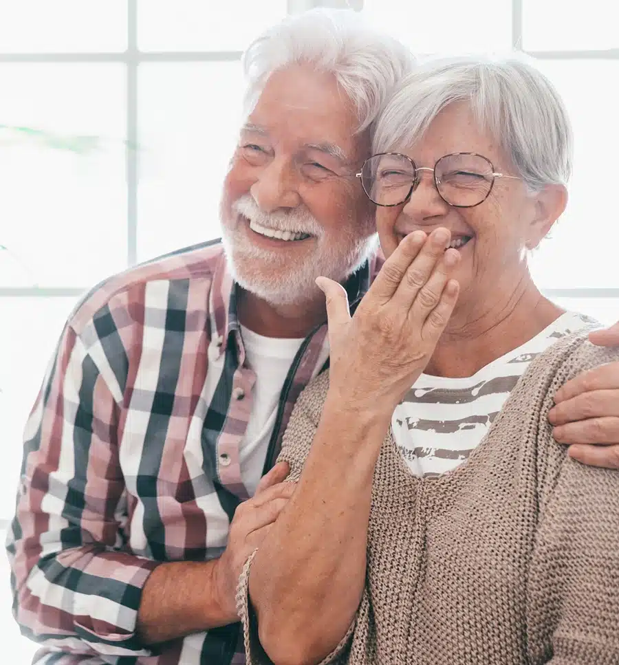 Portrait of happy bonding attractive senior couple at home laugh